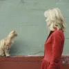 a cat talking to a blond woman