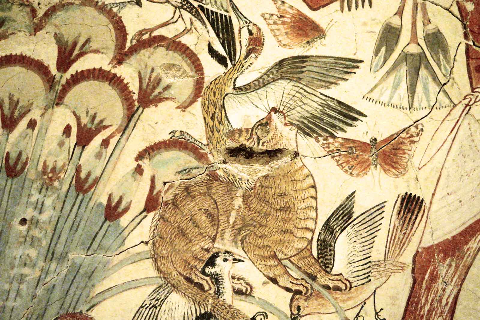Ausschnitt aus dem Wandbildsegment, das eine Katzengestalt inmitten hoher, schlanker Pflanzen zeigt, die mit ihrem Maul und allen vier Pfoten mehrere Vögel fängt.